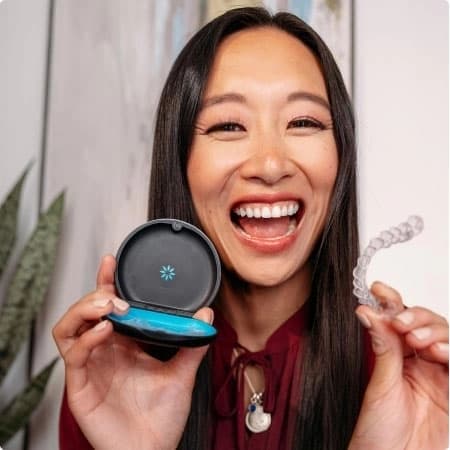 Happy woman showing her Invisalign® aligners in a case