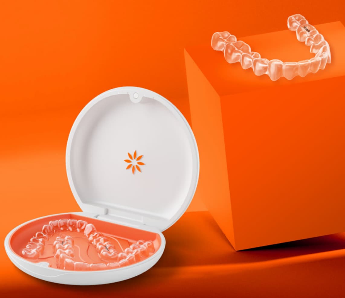 Vivera Retainers in their case on an orange background and sample retainers on an orange podium