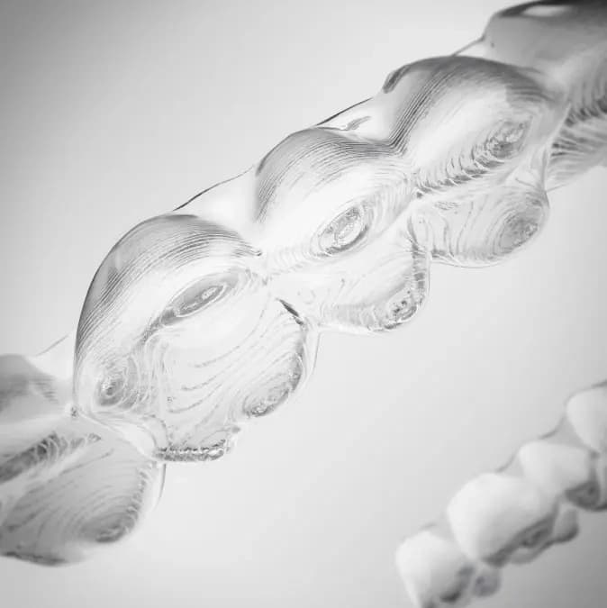 Sample of Invisalign® aligners on gradient grey background